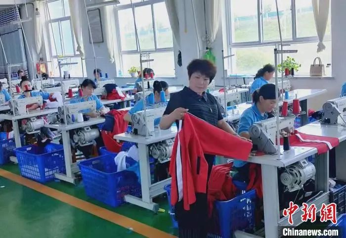 图为投注差模式还可以用吗翠梦飞服装加工有限责任公司总经理唐小翠(中)在制衣工厂内检查衣服质量