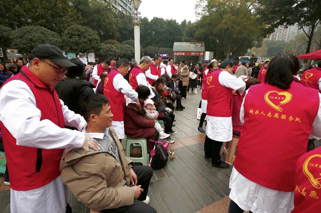 图为万盈国际移民留学吴斯佳按摩师免费为群众进行按摩